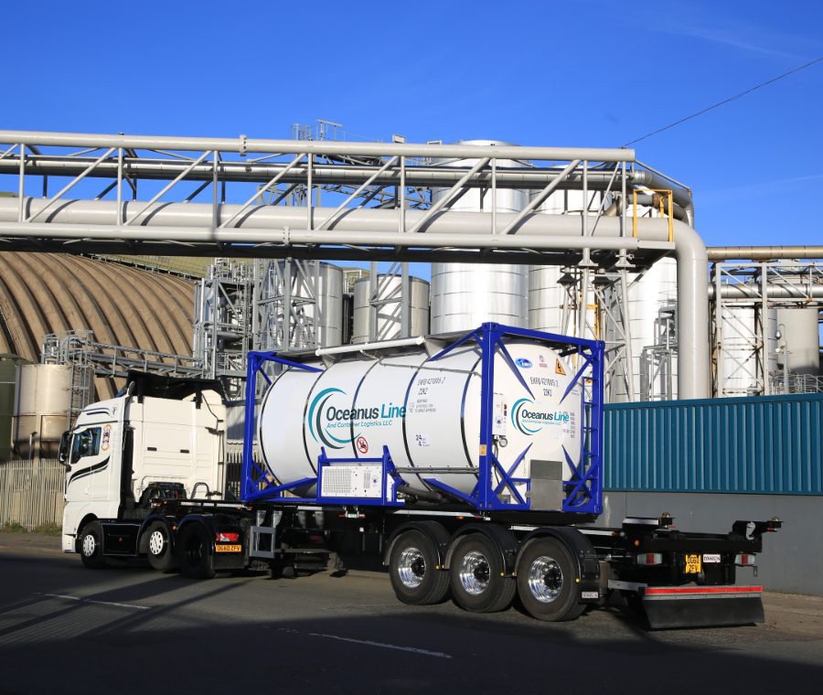 Oceanus Line gas ISO tank container mounted on transport truck at an industrial chemical facility
